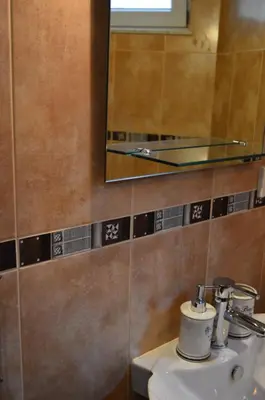 a bathroom with a sink and a mirror and a toilet at Apartments Qualitas in Kotor