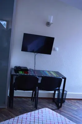 a table with two chairs and a television on a wall at Apartments Qualitas in Kotor