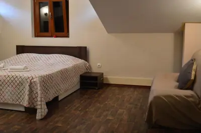 a small bedroom with a bed and a couch at Apartments Qualitas in Kotor