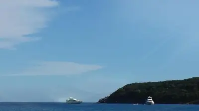 three boats floating in the water near a island at Apartment SVS in Budva