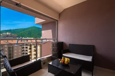 a balcony with two chairs and a table with fruit on it at Apartment SVS in Budva