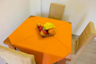 an orange table with a bowl of fruit on it at Apartments Gran Sasso in Ulcinj