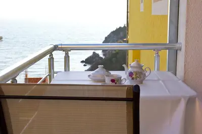 a table with two tea sets on a balcony at Apartments Gran Sasso in Ulcinj