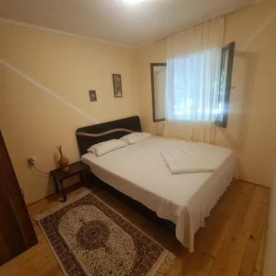 a bedroom with a white bed and a window at Ivan's Holiday Home in Virpazar