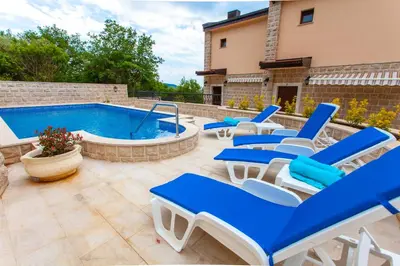 a patio with blue chairs and a swimming pool at Rosmarino in Sveti Stefan