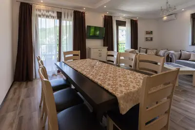 a dining room and living room with a table and chairs at Rosmarino in Sveti Stefan