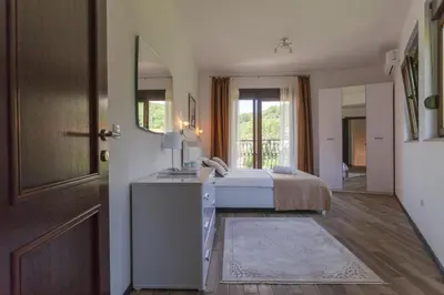 a bedroom with a bed and a mirror and a door at Rosmarino in Sveti Stefan