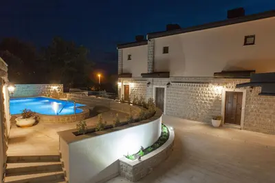a backyard with a swimming pool and a house at Rosmarino in Sveti Stefan