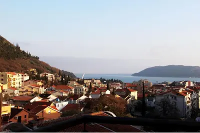 a view of a city with houses and the ocean at Apartman Nina in Budva