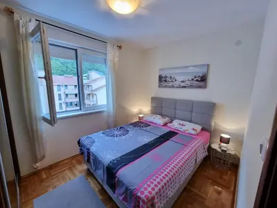 a bedroom with a bed and a window at Apartman Nina in Budva
