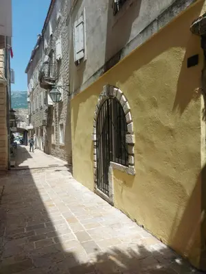 an alley with an iron gate on the side of a building at Old Town Experience - Studio Apartment in Budva