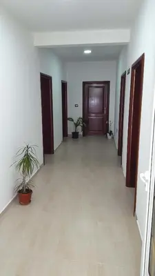an empty hallway with potted plants and a wooden door at Apartments Sirena in Ulcinj