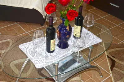 a table with three wine glasses and a vase with roses at Apartments Sirena in Ulcinj