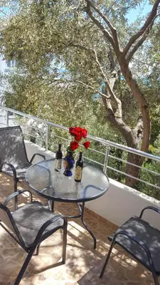 a table with two bottles and flowers on a balcony at Apartments Sirena in Ulcinj