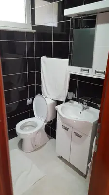 a bathroom with a white toilet and a sink at Apartments Sirena in Ulcinj