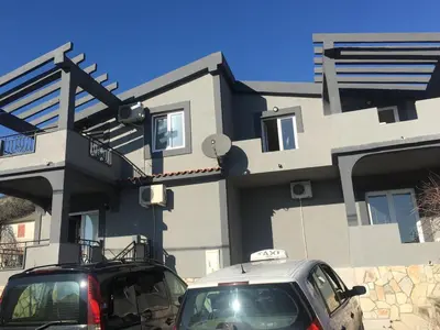 two cars parked in front of a house at Apartmani Miljana in Bar
