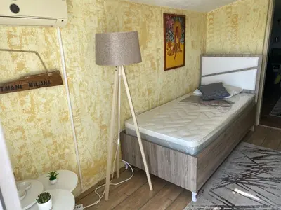 a small bedroom with a bed and a lamp at Apartmani Miljana in Bar