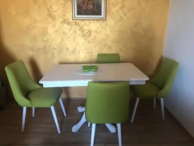 a table with two green chairs and a white table at Apartmani Miljana in Bar