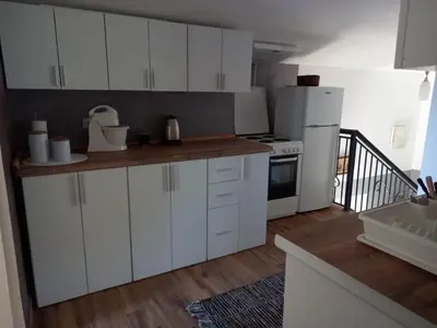 a kitchen with white cabinets and a white refrigerator at Apartmani Miljana in Bar