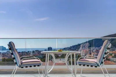 two chairs and a table on a balcony at Villa Blue Panorama in Budva