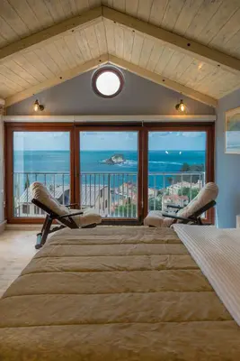 a bedroom with a large bed with a view of the ocean at Medin Apartments BluVista in Petrovac na Moru