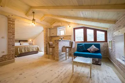a bedroom with a bed and a blue couch in a room at Medin Apartments BluVista in Petrovac na Moru