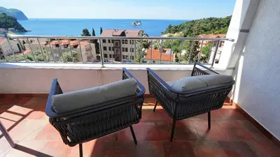 a balcony with two chairs and a view of the ocean at Medin Apartments BluVista in Petrovac na Moru