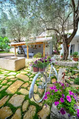 a bike parked in a garden with flowers at Medin Apartments BluVista in Petrovac na Moru
