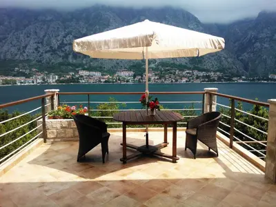 a table and chairs with an umbrella on a balcony at Villa 