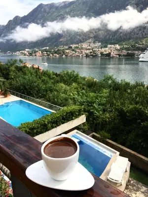 a cup of coffee on a table next to a pool at Villa 