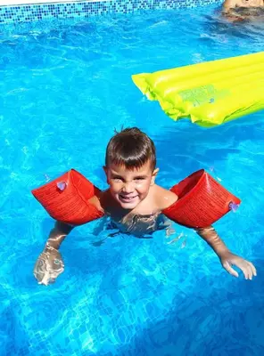 a young boy in the water in a pool at Apartments Maljevic in Bar