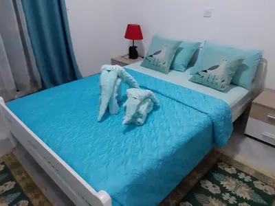 a bedroom with a bed with blue sheets and an elephant pillow at Apartments Maljevic in Bar
