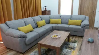 a blue couch with yellow pillows in a living room at Apartments Maljevic in Bar