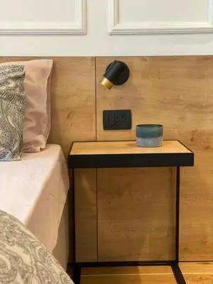 a nightstand with a clock on it next to a bed at VilaA21 in Bar