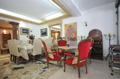 a dining room with a table and red chairs at Hotel Oaza in Budva