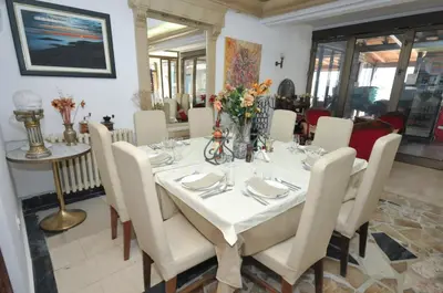 a dining room with a white table and chairs at Hotel Oaza in Budva