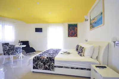 a bedroom with a bed and a table with a chair at Hotel Oaza in Budva