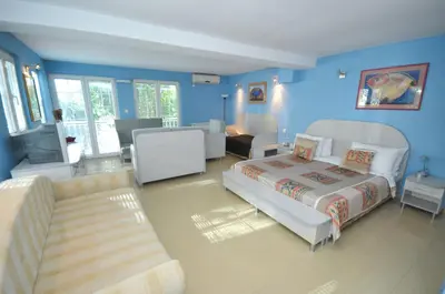 a blue room with a bed and a couch at Hotel Oaza in Budva