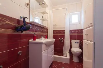 a bathroom with a white sink and a toilet at Hana Accommodation in Sveti Stefan
