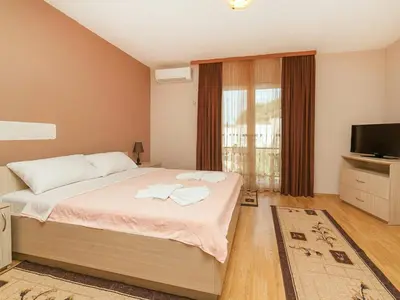 a bedroom with a large bed and a television at Hana Accommodation in Sveti Stefan