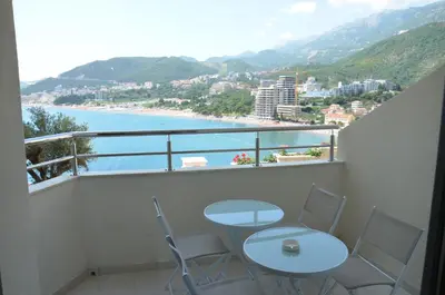 a balcony with tables and chairs and a view of the ocean at Apartmani Svetionik in Budva