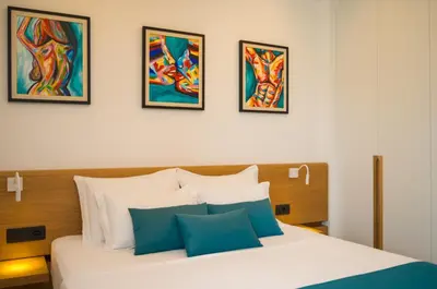 a bedroom with a bed with four pictures on the wall at Hotel Admiral in Budva