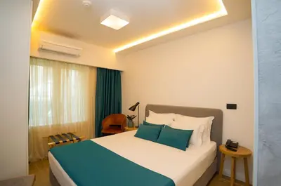 a bedroom with a bed with blue and white pillows at Hotel Admiral in Budva