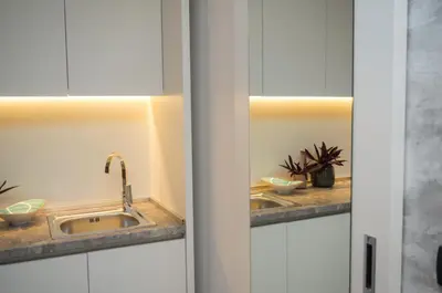 a kitchen with white cabinets and a sink at Hotel Admiral in Budva