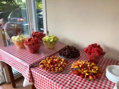 a table with bowls of fruit on a red checkered table cloth at Apartments Cungu in Ulcinj