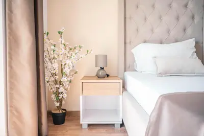 a bedroom with a bed and a nightstand with a plant at Apartments Cungu in Ulcinj