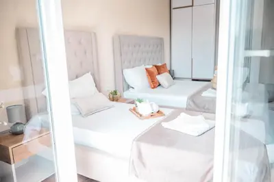 two beds in a room with a mirror at Apartments Cungu in Ulcinj