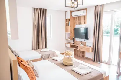 a hotel room with two beds and a television at Apartments Cungu in Ulcinj