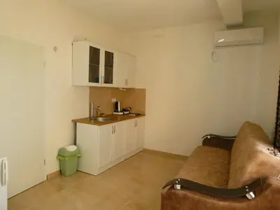 a living room with a couch and a kitchen at Apartments In Amor in Ulcinj