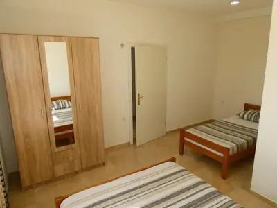 a room with two beds and a door with a mirror at Apartments In Amor in Ulcinj